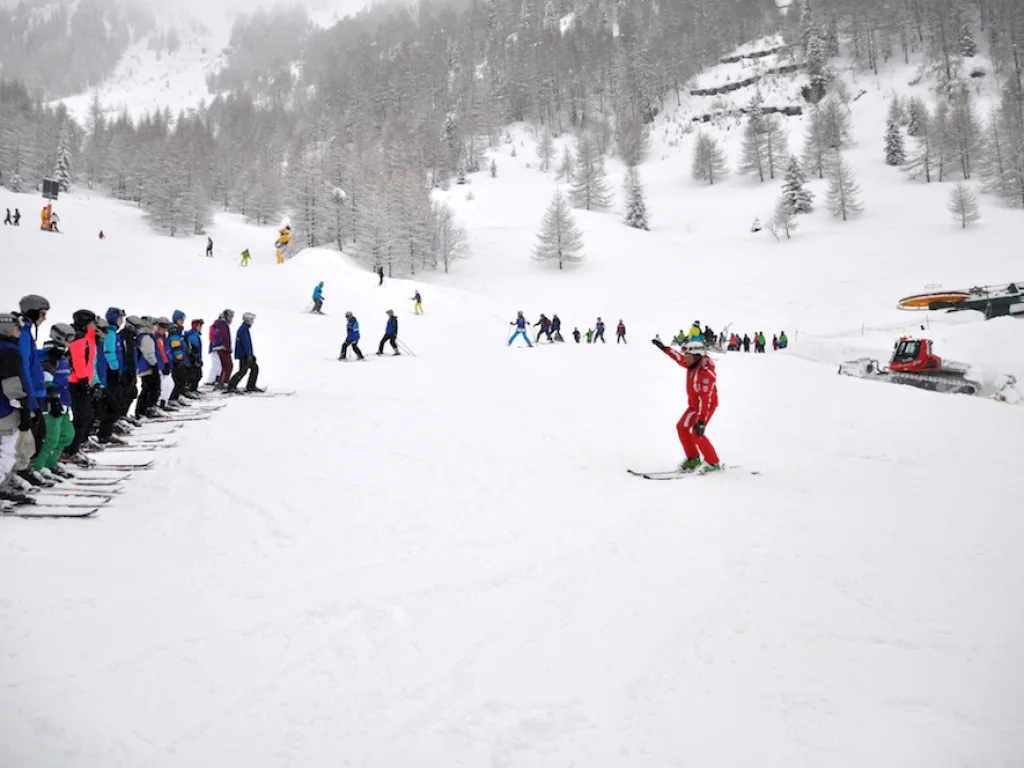 Person mit erhobenen Armen auf der Piste im Nebel.